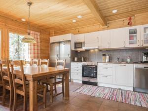 a kitchen with a wooden table and a wooden ceiling at Holiday Home Koparanperä by Interhome in Kakslauttanen
