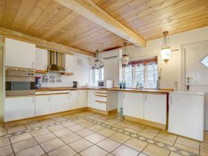 eine Küche mit weißen Schränken und einer Holzdecke in der Unterkunft Holiday Home Evie - all inclusive - in Western Jutland by Interhome in Højer