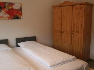 a bedroom with two beds and a wooden cabinet at Holiday Home Landhaus St- Georg-9 by Interhome in Bad Gastein