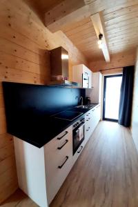 uma cozinha com uma bancada preta e paredes de madeira em Holiday Home Alpenchalets Nassfeld-Rattendorf-3 by Interhome em Jenig