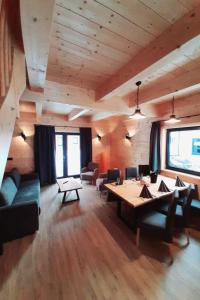 uma sala de estar com uma grande mesa e cadeiras em Holiday Home Alpenchalets Nassfeld-Rattendorf-3 by Interhome em Jenig