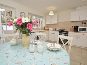 a kitchen with a table with a vase of flowers on it at 2 Bed in West Bay 77557 in Loders