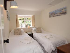 two white beds in a room with a window at 2 Bed in West Bay 77557 in Loders