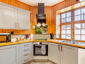 a kitchen with white cabinets and a sink at 2 Bed in Withypool 77362 in Withypool