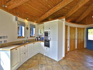 a kitchen with white cabinets and a wooden ceiling at 1 Bed in Acharacle CA368 in Kilchoan