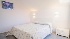 Habitación blanca pequeña con cama y mesita de noche en Loft ad un Passo dal Cielo - Italian Homing, en Desenzano del Garda