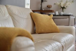 a white couch with a yellow pillow on it at Tęczowa Apartment in Wrocław by Rent like home in Wrocław