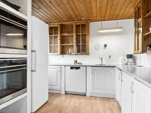 a kitchen with white cabinets and a wooden ceiling at Holiday Home Sune - 6km from the sea in NW Jutland by Interhome in Thisted