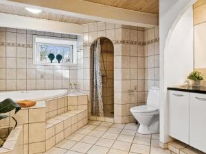 a bathroom with a tub and a toilet at Holiday Home Sune - 6km from the sea in NW Jutland by Interhome in Thisted
