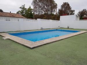 a swimming pool in a yard with a white fence at Chalet independiente en zona residencial rural con piscina privada in Jaén