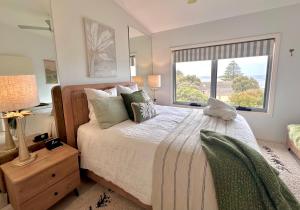 1 dormitorio con 1 cama grande y ventana en The Salty Seagull – ocean-view luxe!, en Encounter Bay