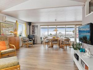 ein Wohnzimmer mit einem Esstisch und einem TV in der Unterkunft Holiday Home Oskari - 175m from the sea in Sealand by Interhome in Slagelse