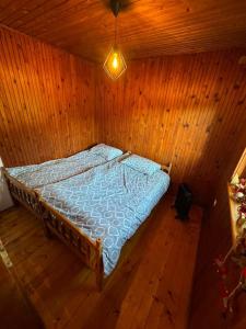 a bedroom with a bed in a wooden room at Romantična vikendica in Pale