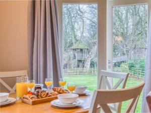 a table with a plate of food and glasses of orange juice at 2 Bed in Nr Beadnell 77990 in Ellingham