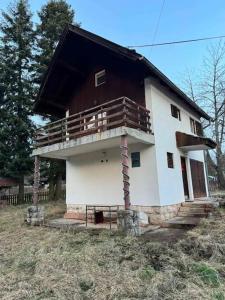 a house with a balcony on top of it at Romantična vikendica in Pale