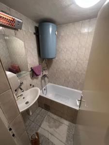 a small bathroom with a tub and a sink at Romantična vikendica in Pale