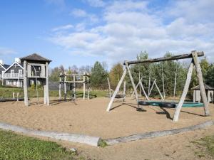 an empty playground with two swings in the sand at Holiday Home Tian in SE Jutland by Interhome in Gjern