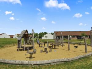 a playground with benches and swings in the sand at Holiday Home Tian in SE Jutland by Interhome in Gjern