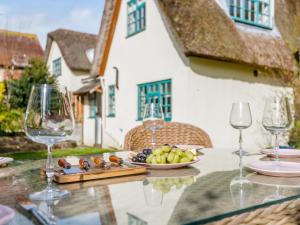 a table with wine glasses and a plate of fruit at 3 Bed in Wool 77787 in Wool