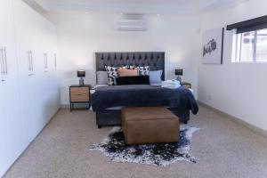 a bedroom with a large bed with a blue bedspread at Waterfront Boutique Hotel Vanderkloof in Vanderkloof