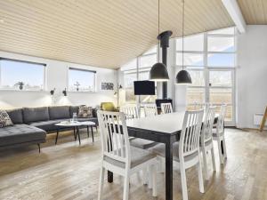 een eetkamer en een woonkamer met een tafel en stoelen bij Holiday Home Rudy - 800m from the sea in NW Jutland by Interhome in Løkken