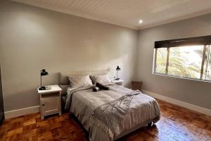 a bedroom with a large bed and a window at Embassy Apartment in Cape Town