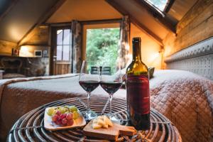 una mesa con dos copas de vino y una botella en Glamping Pian delle Ginestre, en Sassetta