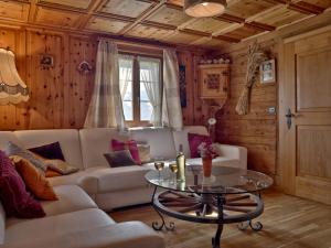 Holiday Home Chalet Zun by Interhome في سارمن: غرفة معيشة مع أريكة بيضاء وطاولة زجاجية