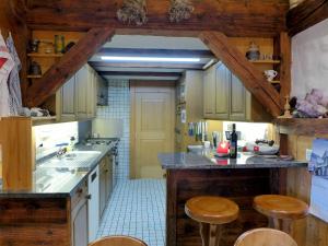 a kitchen with wooden cabinets and wooden stools at Holiday Home Chalet Zun by Interhome in Sarnen