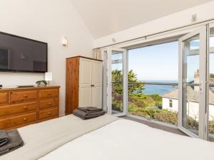 a bedroom with a large bed and a large window at 5 Bed in Mortehoe 76593 in Mortehoe