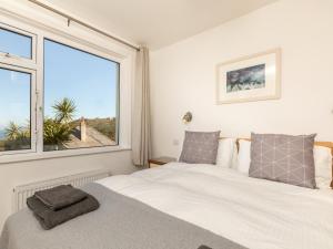 a bedroom with a bed and a large window at 5 Bed in Mortehoe 76593 in Mortehoe