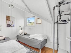 een slaapkamer met een bed in een witte kamer bij Holiday Home Anu - 400m from the sea in SE Jutland by Interhome in Aabenraa