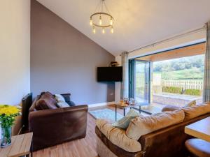 a living room with leather furniture and a large window at 2 Bed in Bewdley 77721 in Highley