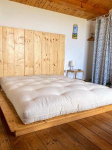 1 dormitorio con 1 cama grande y cabecero de madera en Stanza panoramica con terrazza privata sul mare, en Marzamemi