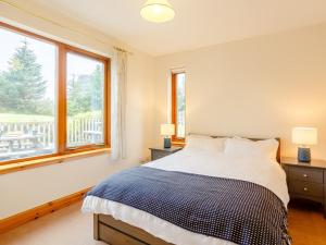 a bedroom with a bed and a large window at 4 Bed in Badachro CA390 in Strath