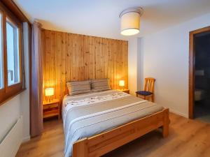 Bett in einem Zimmer mit einer Holzwand in der Unterkunft Apartment Mandarin-5 by Interhome in Crans-Montana