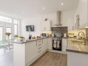 a kitchen with white cabinets and a counter top at 1 Bed in Old Colwyn 78154 in Old Colwyn