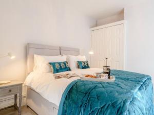 a bedroom with a large bed with a blue blanket at 1 Bed in Old Colwyn 78154 in Old Colwyn