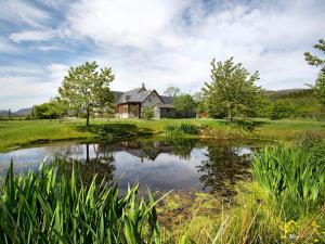 a house with a pond in front of it at 2 Bed in Ardross CA384 in Stittenham