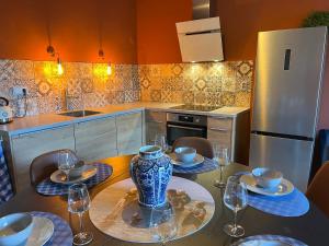 uma cozinha com uma mesa com pratos e copos de vinho em Guesthouse by C em Colijnsplaat