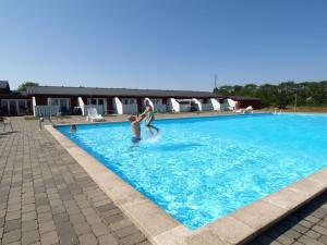 a man and a child playing in a swimming pool at Holiday Home Thorulf - 6km from the sea in Bornholm by Interhome in Åkirkeby