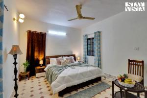 - une chambre avec un lit et un ventilateur de plafond dans l'établissement StayVista's Palm Perle Villa - Pet-Friendly Retreat with Terrace, Lawn & Pool Table, à Bhopal