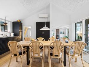 eine Küche und ein Esszimmer mit einem Holztisch und Stühlen in der Unterkunft Holiday Home Scarlett - 110m from the sea in Djursland and Mols by Interhome in Ebeltoft