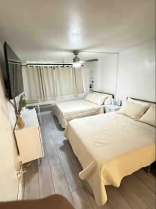 a bedroom with two beds and a tv in it at OCEAN FRONT Condo On The Beach in Daytona Beach
