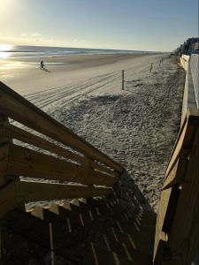 a sandy beach with a person riding a bike on it at OCEAN FRONT Condo On The Beach in Daytona Beach