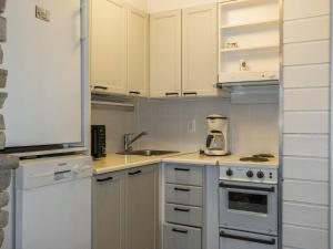uma cozinha com armários brancos e um aparelho branco em Holiday Home Auroora by Interhome em Sirkka