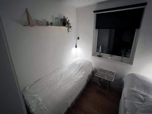a bedroom with two twin beds and a window at Holiday Home Keti - 50m from the sea in NE Jutland by Interhome in Hadsund