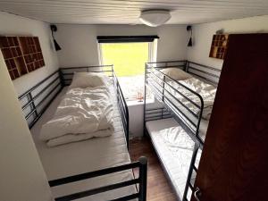 two bunk beds in a room with a window at Holiday Home Keti - 50m from the sea in NE Jutland by Interhome in Hadsund