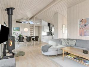 a living room with a couch and a fireplace at Holiday Home Mirla - 50m from the sea in NW Jutland by Interhome in Saltum