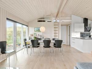 een keuken en eetkamer met een tafel en stoelen bij Holiday Home Mirla - 50m from the sea in NW Jutland by Interhome in Saltum